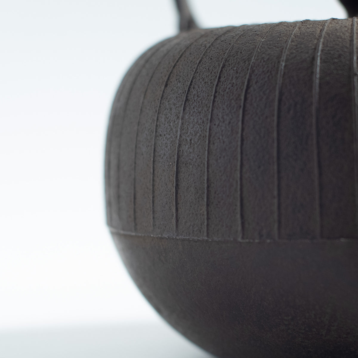 Iron Kettle with Vertical Stripe Pattern and Flat Circular Shape