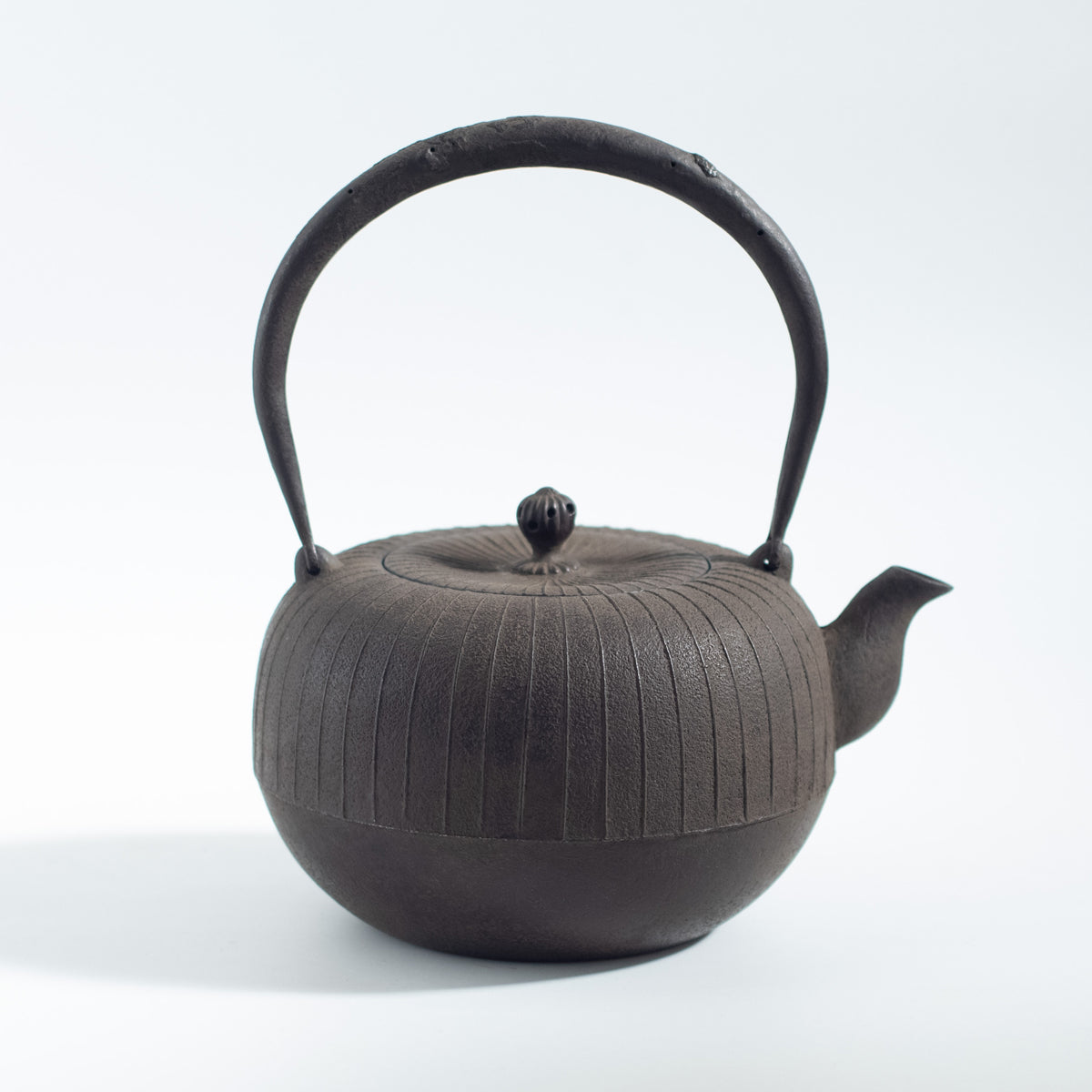 Iron Kettle with Vertical Stripe Pattern and Flat Circular Shape