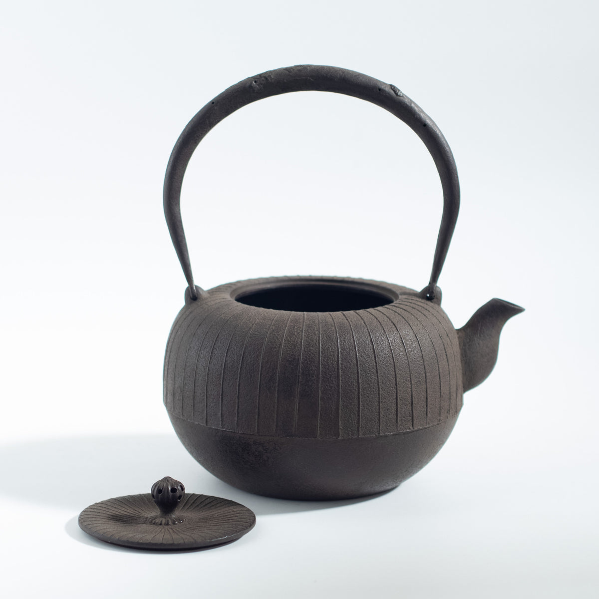 Iron Kettle with Vertical Stripe Pattern and Flat Circular Shape