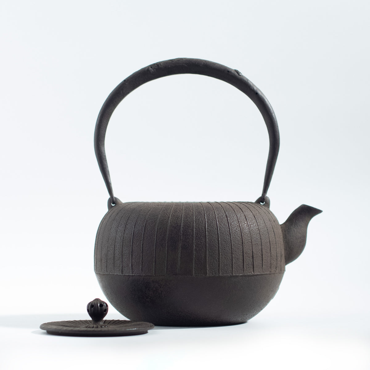 Iron Kettle with Vertical Stripe Pattern and Flat Circular Shape