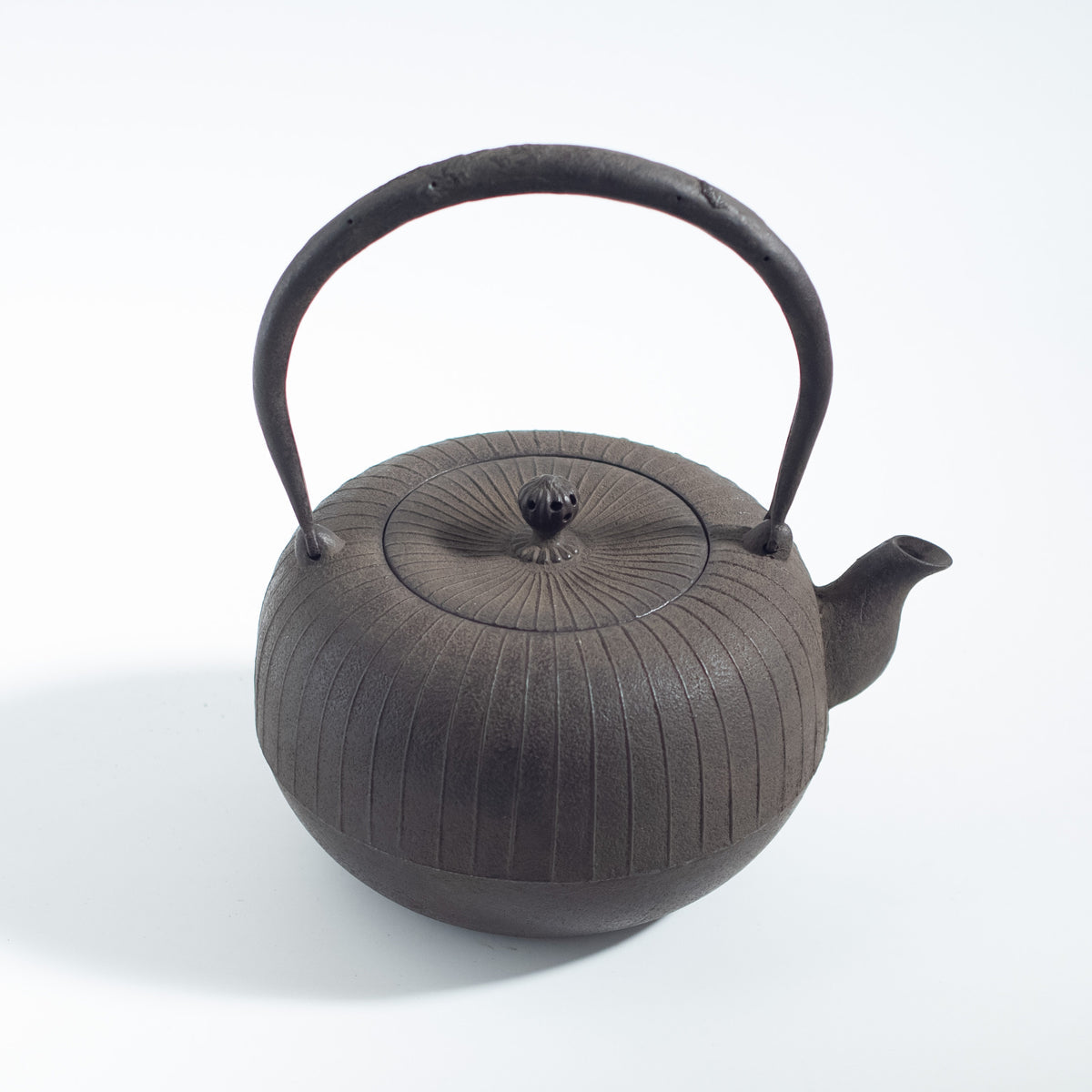 Iron Kettle with Vertical Stripe Pattern and Flat Circular Shape